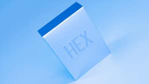 Close-up of a blue HEX card with embossed text, floating in the air.