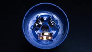 Close-up of Nova Rings magic trick with metallic rings in a blue container.