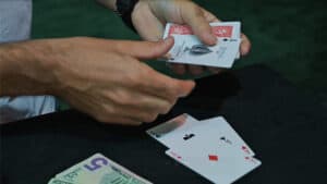 Close-up of a magician performing a card trick with playing cards.