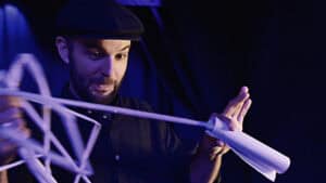 Performer demonstrating the Mouth Coil Pro magic trick with a paper roll.