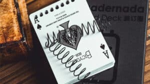 Close-up of a playing card with a metal spring, part of the Bound Deck by Juan Luis Rubiales and Bac.