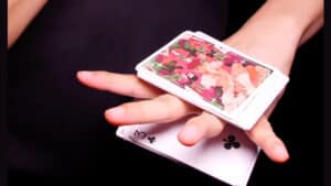 Performer demonstrating a magic card trick with Eldra playing cards in hand.