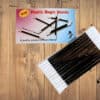 Set of 12 black plastic magic wands for magic tricks and performances.