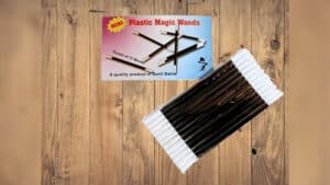 Set of 12 black plastic magic wands for magic tricks and performances.