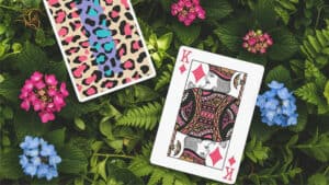 Playing card with a vibrant leopard print design on a lush green background.