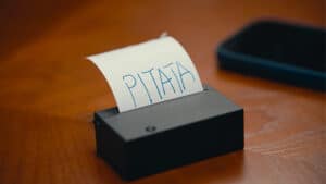 Compact PITATA MAGIC mini smart printer printing handwritten notes.