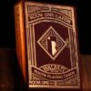 Room One Walnut Roots playing cards box with intricate design on black background.