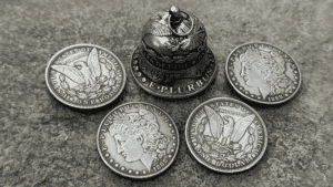 Coin Bell illusion with coins and a small bell for magic tricks.