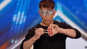 Cyril performing card magic with a deck during a magic show.