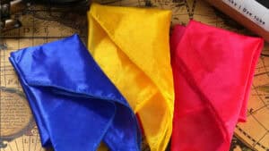 Bright blue, yellow, and pink silk hankies used in magic tricks.