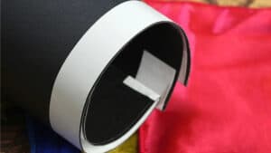 Close-up of a magician's hand performing the Chameleon Hanky trick with a black and white prop.
