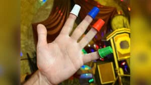Hand with colorful thimbles performing magic trick for entertainment.