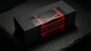 Close-up of a black box with red "PROJECT H" logo on a dark surface.