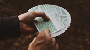 Hand holding a fan of Orbit Forest playing cards for magic tricks and card illusions.