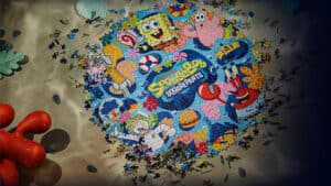 Colorful SpongeBob SquarePants jigsaw puzzle on sandy beach.