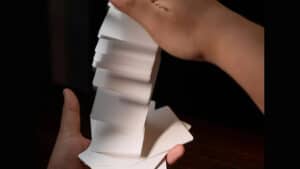 Close-up of a hand holding a blank Svengali deck for magic tricks.