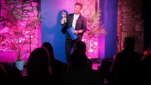 Performer Luke Oseland demonstrates a magical drink trick during a live show.