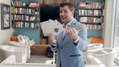 Magician performing Jumbo McDonald Aces card trick with red back cards.
