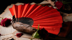 Elegant red fan with butterfly illusion for magic performances.