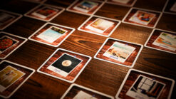 Close-up of a card game spread on a wooden table, featuring various colorful cards from 
