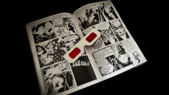 Close-up of comic book pages with a magic illusion prop on a dark background.