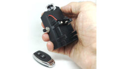 Hand holding remote control device for flying silk magic trick.