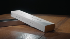 Close-up of a graphite stick on a wooden surface, part of the Romuald Barbey series.