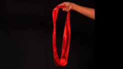 Hand holding a red silk circle for magic illusions, King Solomon's Circle trick.