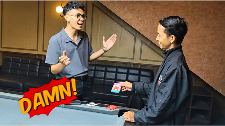 Young magician performing a card trick for an amazed audience member.