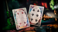 Close-up of playing cards with keyhole reflections on a colorful wall background.