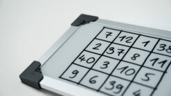 Whiteboard with numbered grid for magic trick practice and illusions.