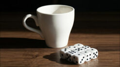 Large white ceramic cup with dice for magic tricks.