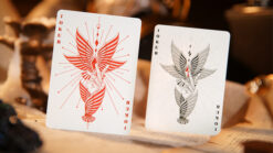 Close-up of Mr. Black V2 red playing cards with intricate bird design for magic tricks.