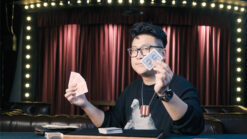 Magician performing the Right Bill (EUR) card trick on stage with playing cards.