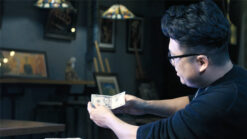 Magician Wang Zhe performs a bill trick with British pounds in a cozy setting.