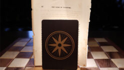 Close-up of a magic trick card with a star symbol on a wooden table.