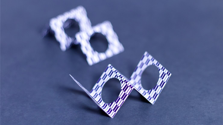 Magician performing zig zag penetration with paper squares and a pen.