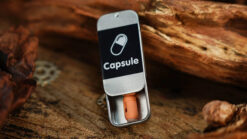 Close-up of a magic capsule trick with a small pill in a metal case.