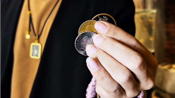 Close-up of a hand performing the Wing Coin illusion by Harry He & Bacon Magic.