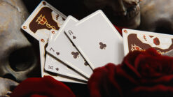 Gilded playing cards featuring skull and rose designs, perfect for magic tricks and card enthusiasts.
