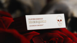 Elegant skull and rose playing cards with gilded accents, perfect for magic tricks and card enthusia.