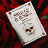 Elegant skull and roses themed playing cards with gilded edges, perfect for magic tricks and card en.
