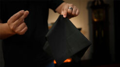 Hand holding a black Tri-Vanish handkerchief for magic tricks demonstration.